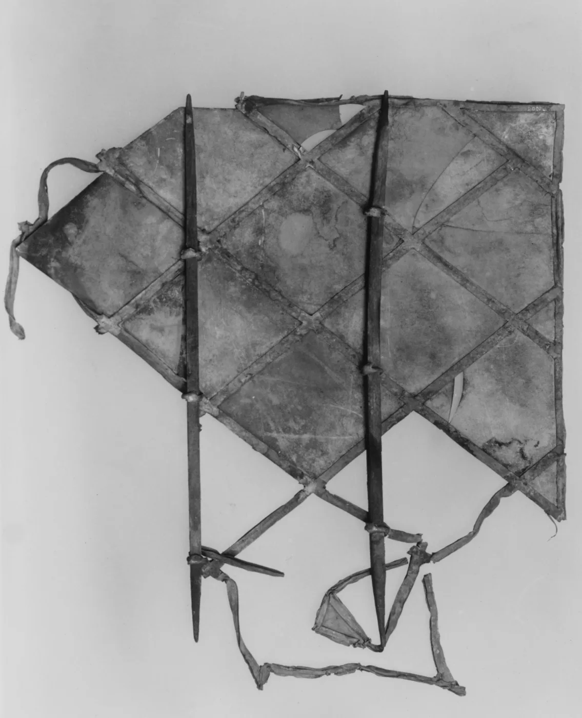 Fragment of a diamond-paned leaded casement window against a grey background