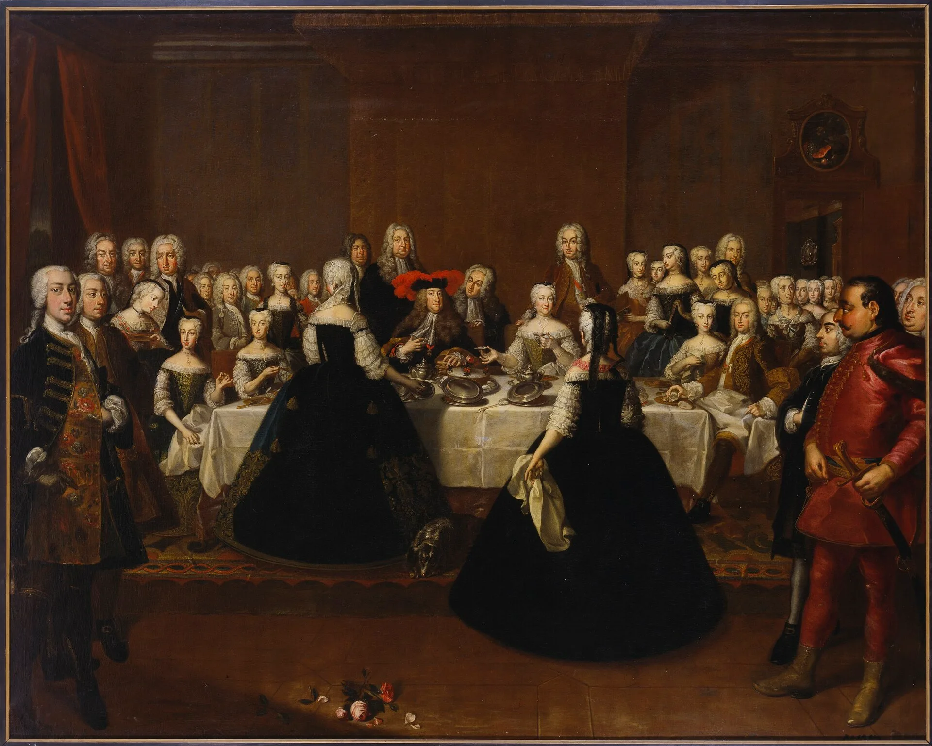 Eighteenth-century painting of courtiers gathered around a long dinner table laid with dishes