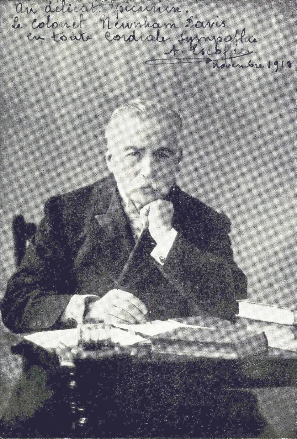 Black and white photograph of Auguste Escoffier seated at a desk