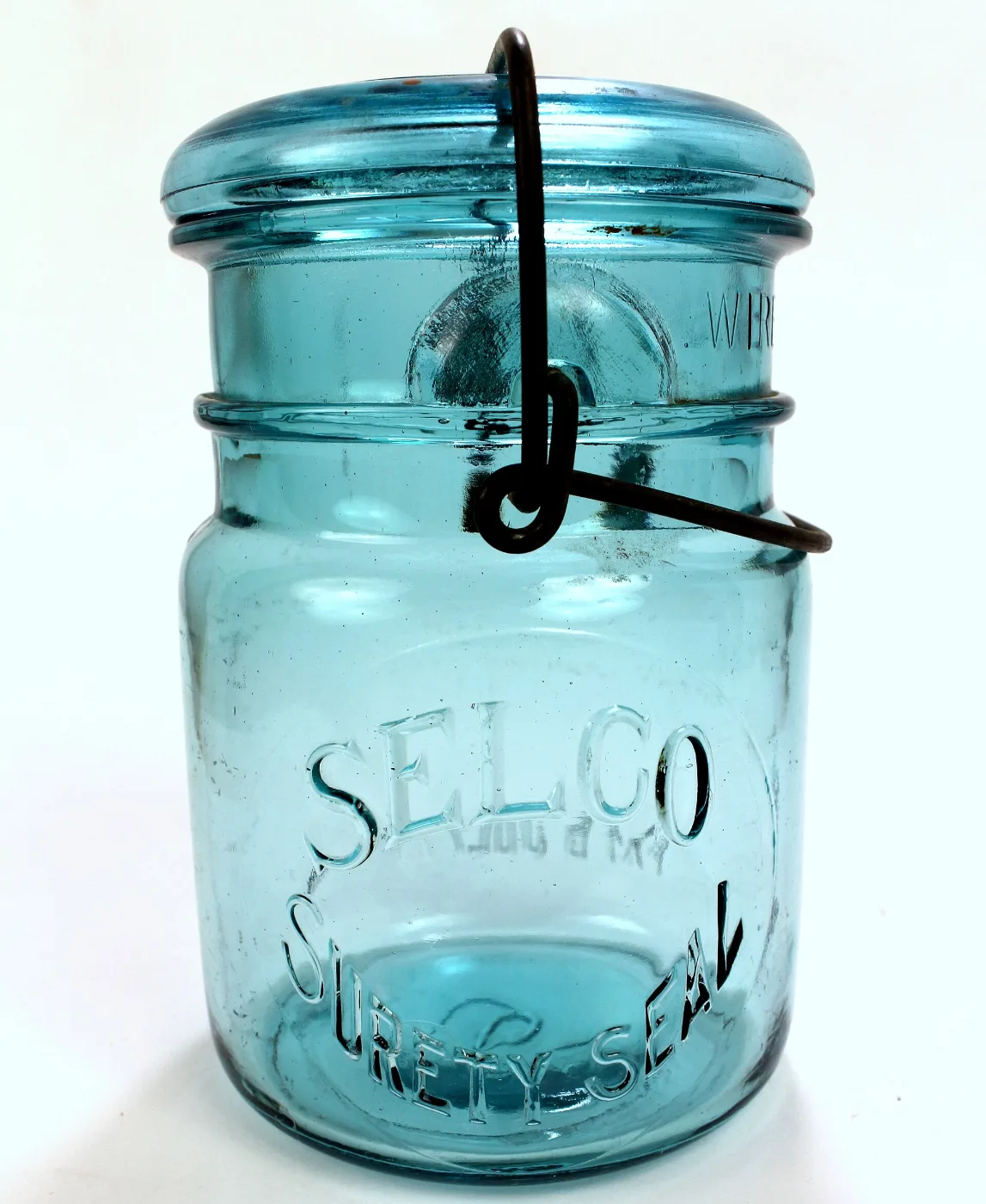 Blue glass fruit jar with embossed lettering and a wire bail closure
