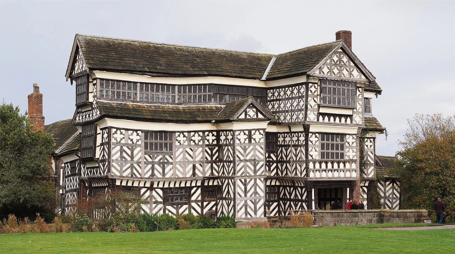Black and white timber-framed manor house with jettied gables and decorative panels