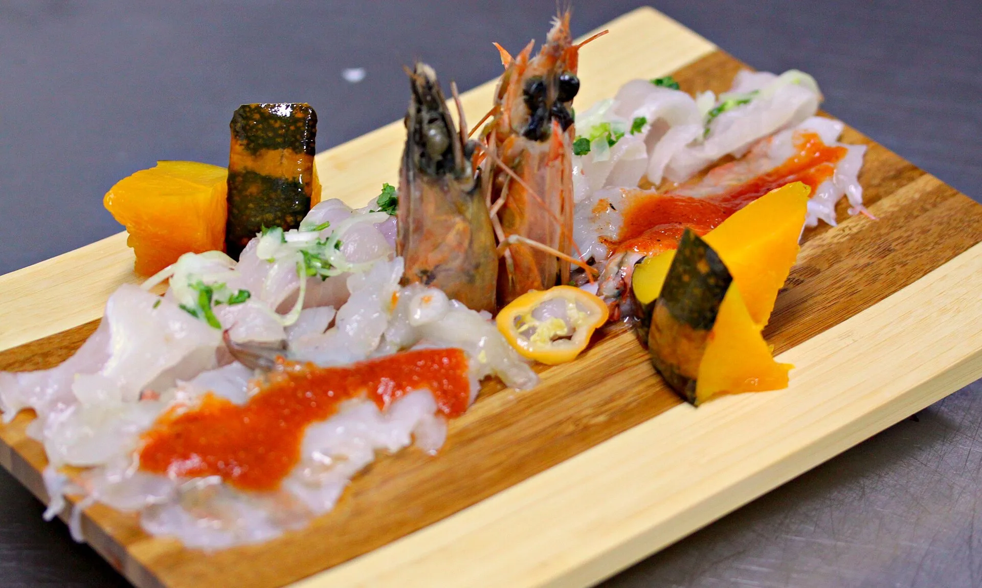 Thin slices of raw fish in sauce on white plates