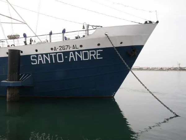Bow of a dark blue trawler with the name Santo André on its hull