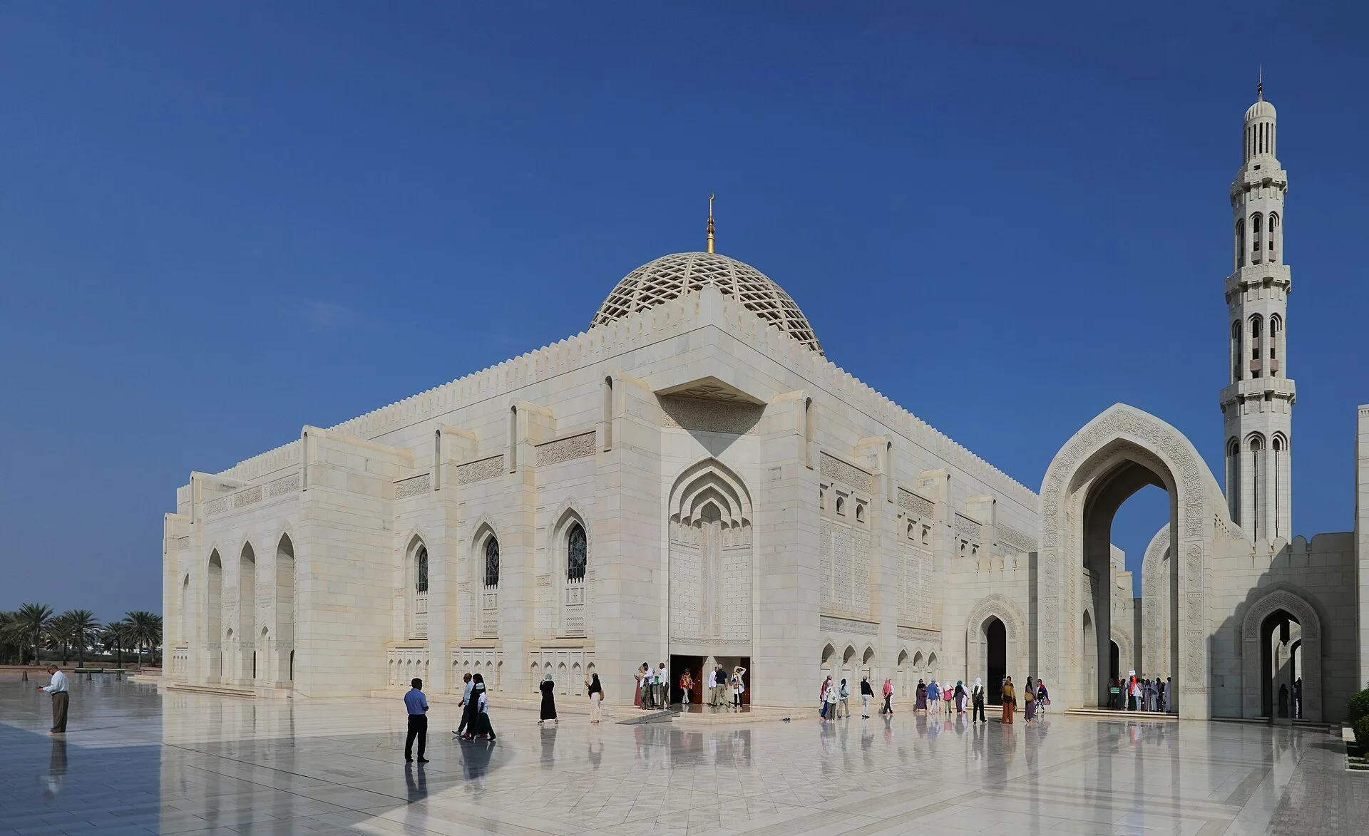 White mosque with a large dome and a tall minaret under a blue sky