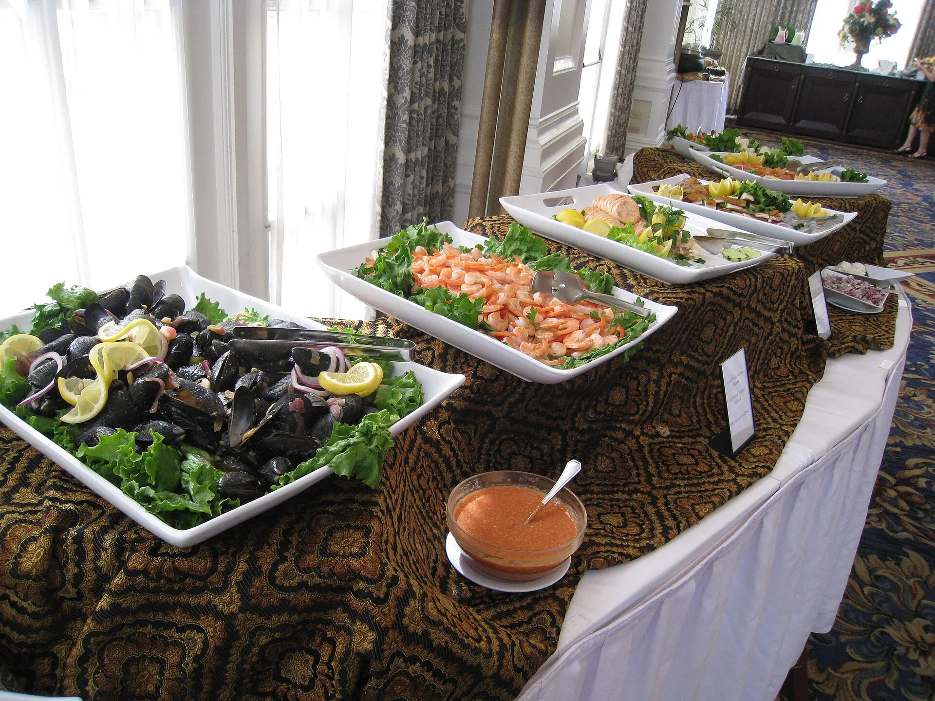 Hotel brunch buffet table with platters of salads and seafood