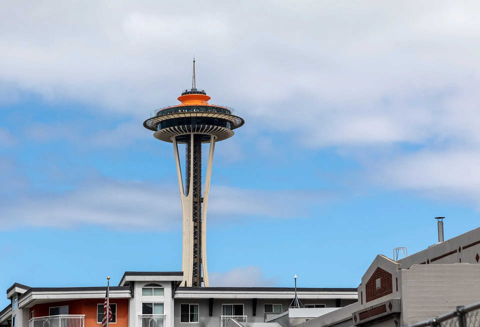 The Space Needle's saucer-shaped top house on a slender tower against a cloudy sky