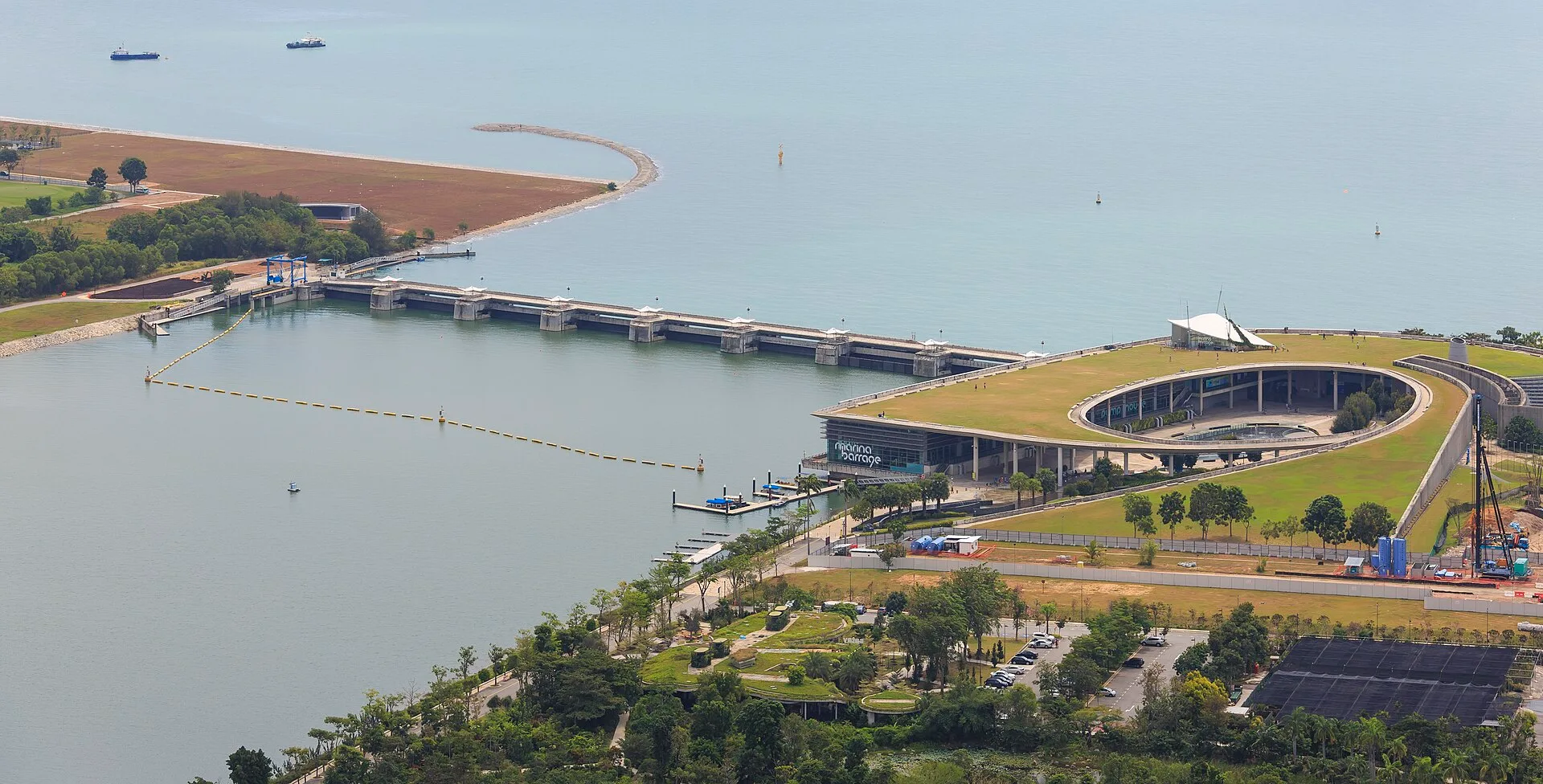 Dam across a channel with a green roofed building beside it