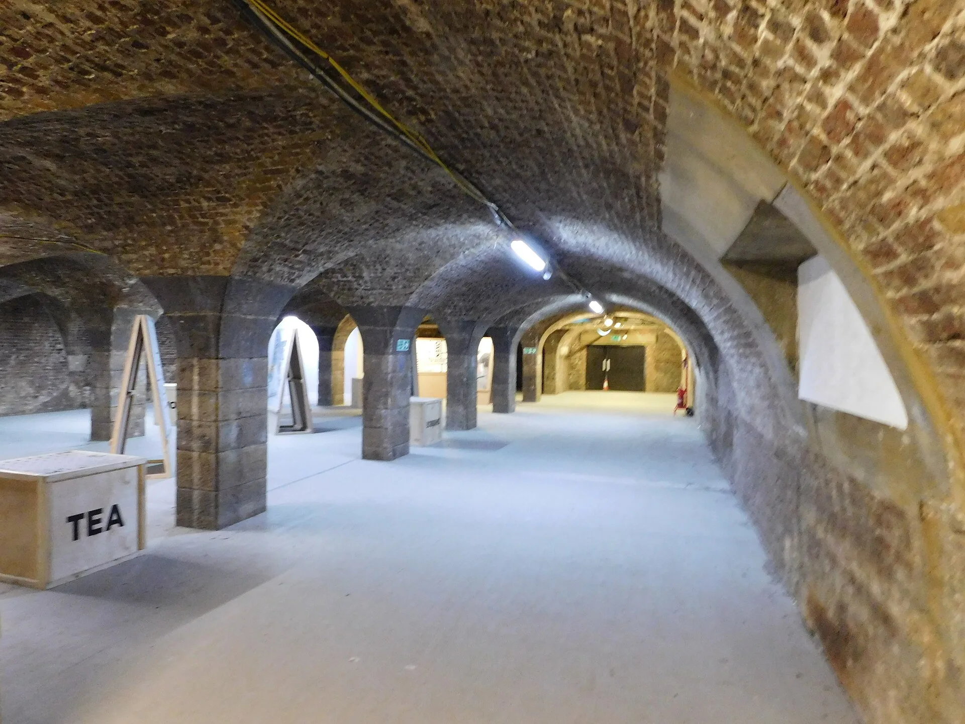 Brick barrel vaults on stone piers stretching into the distance underground