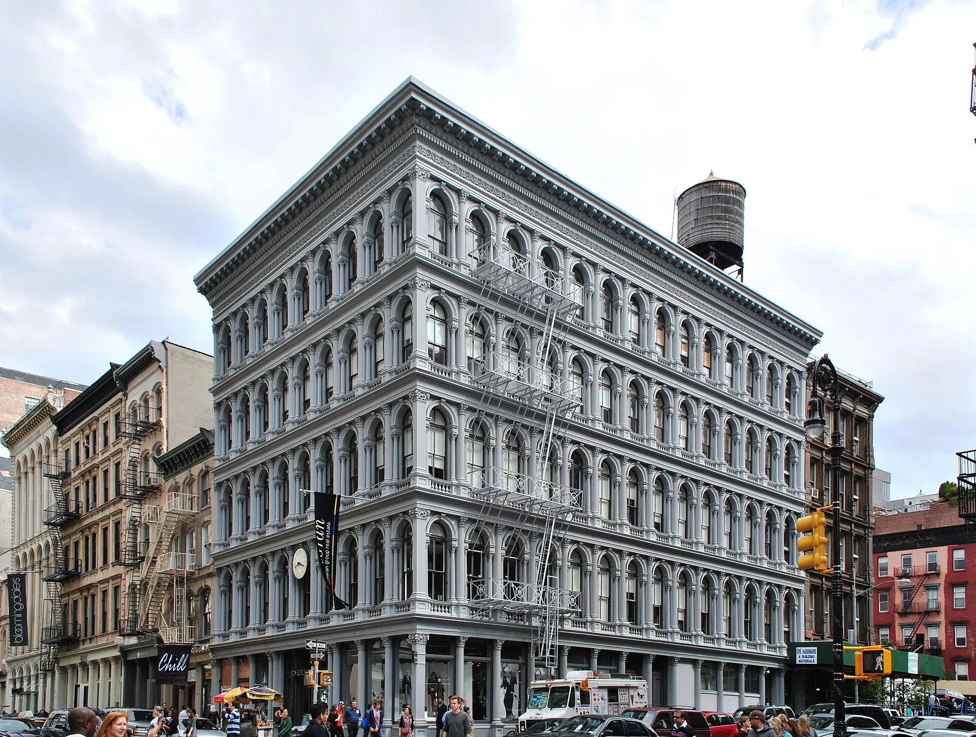 Five-storey cast-iron building with rows of arched windows on a street corner