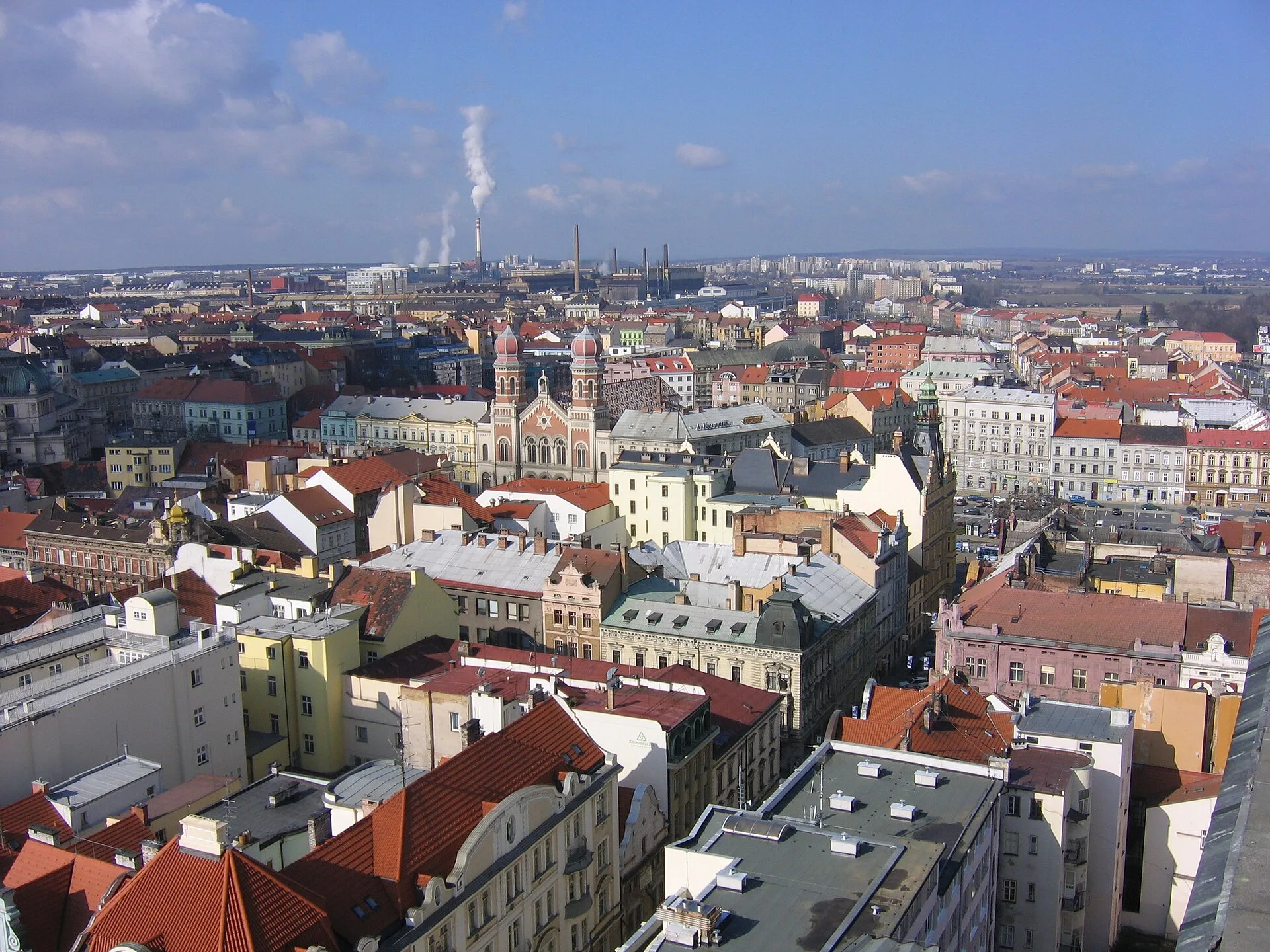Red-roofed city blocks stretching to the horizon seen from a church tower
