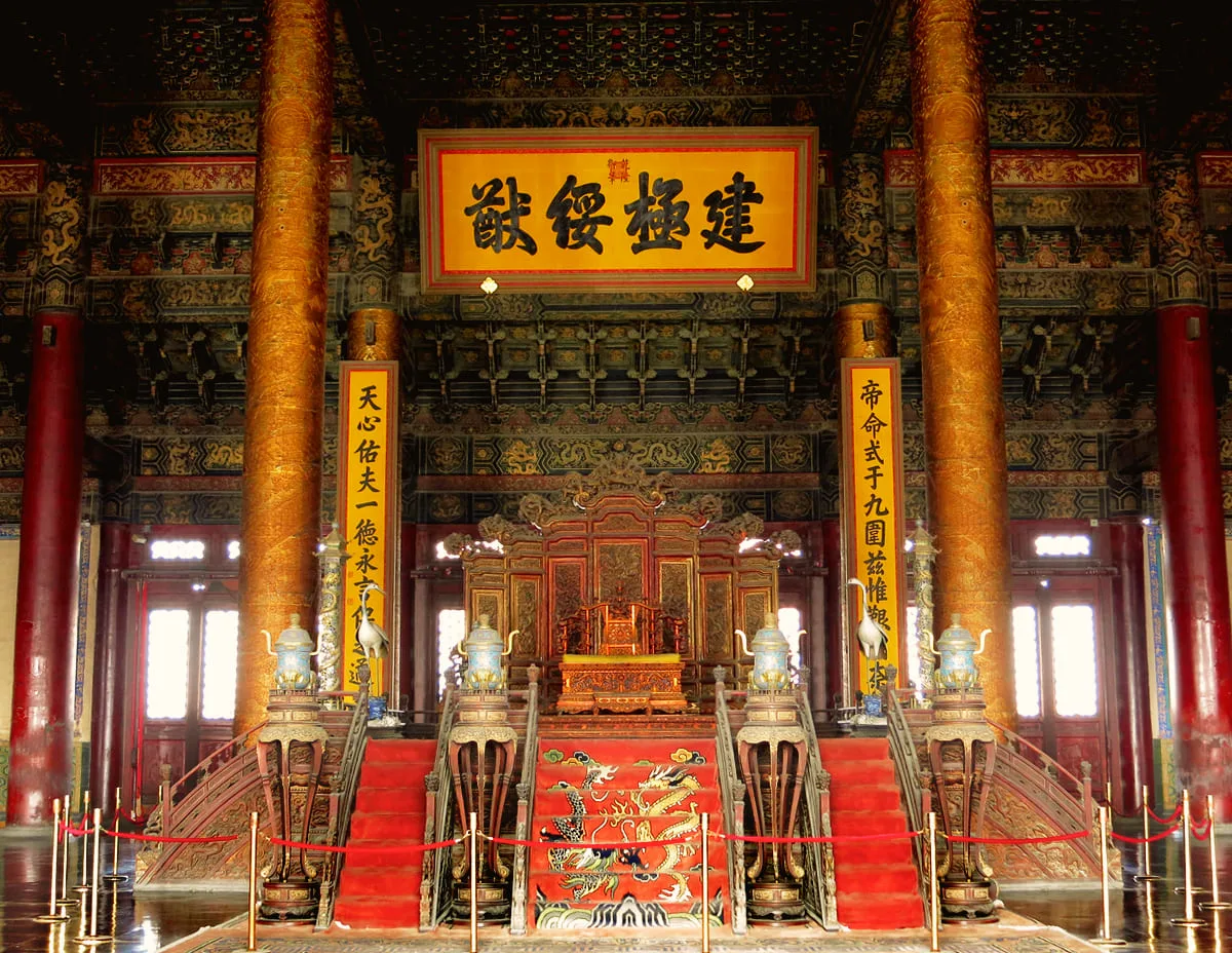 Gilded throne on a raised platform between red and gold columns
