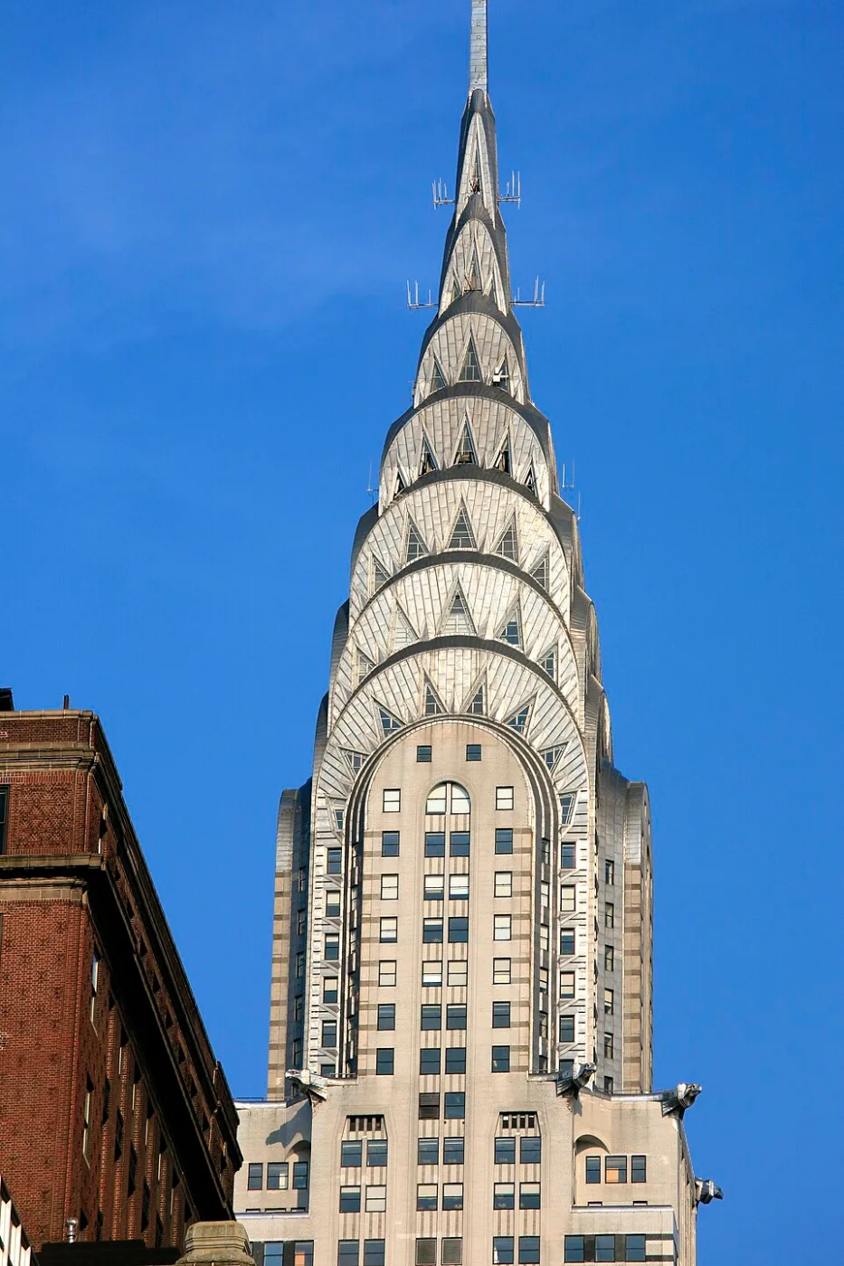 Stepped metal crown and spire of the Chrysler Building against blue sky