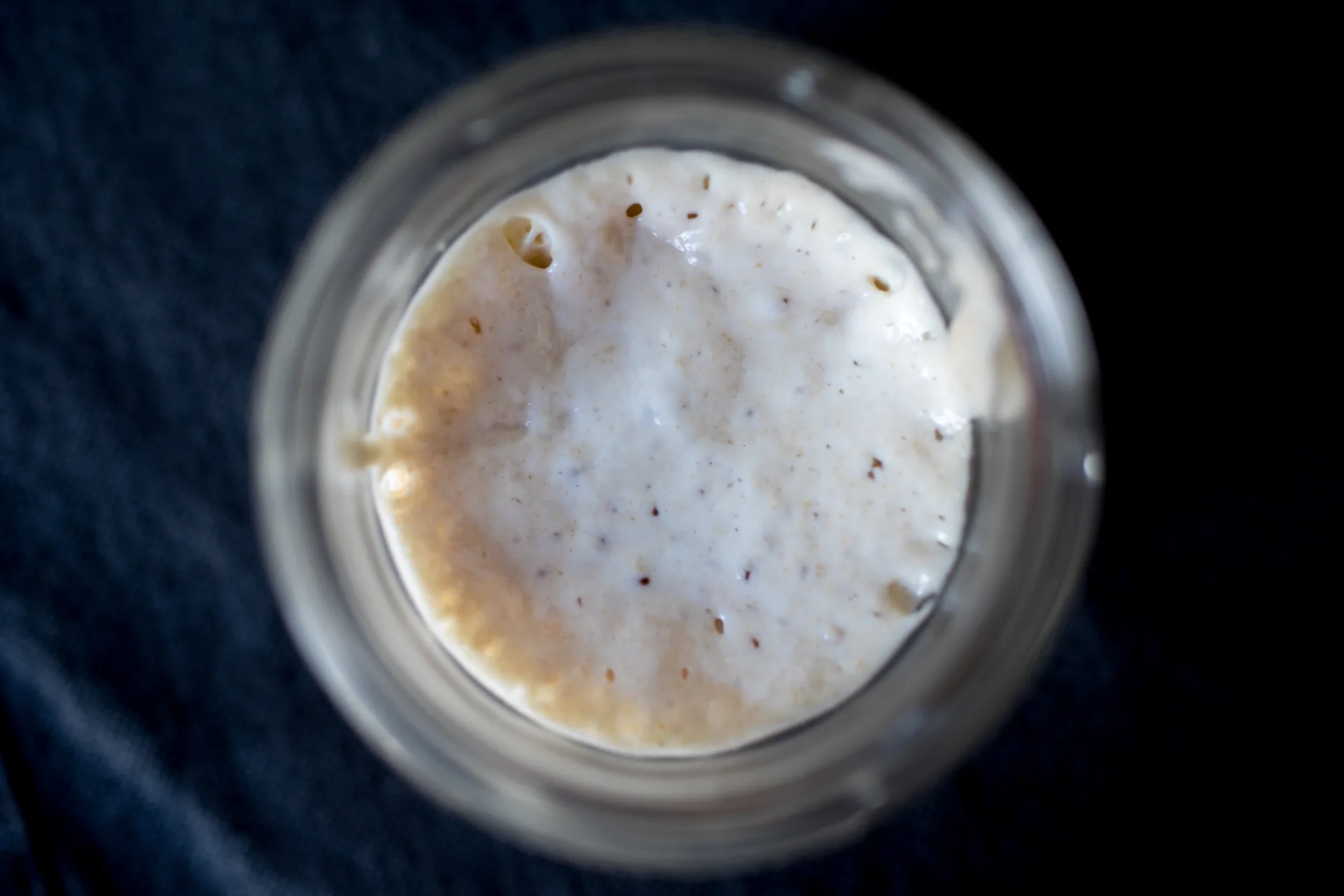 Bubbling sourdough starter seen from above in a glass jar