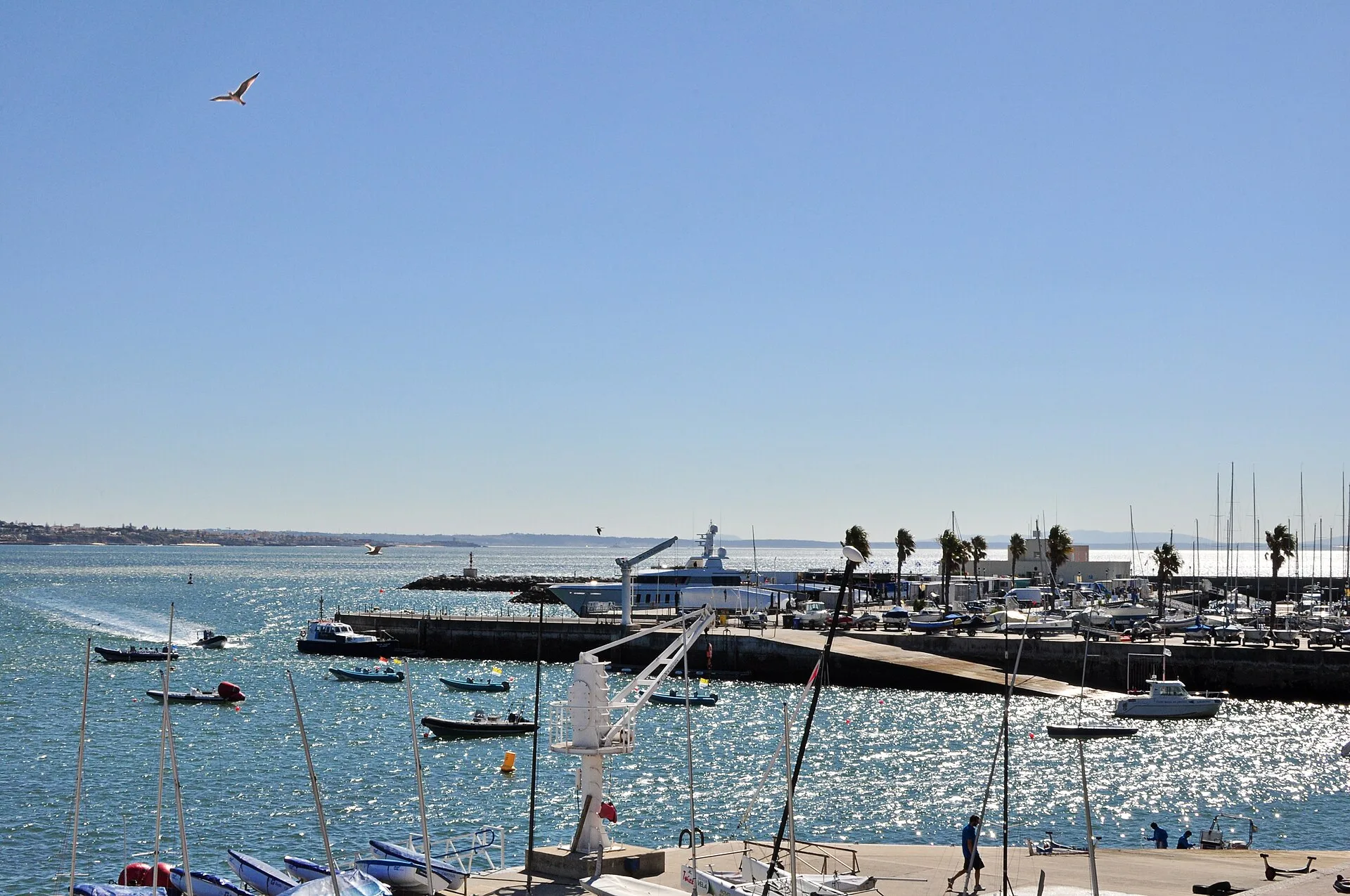 Calm bay with moored boats and a seafront town