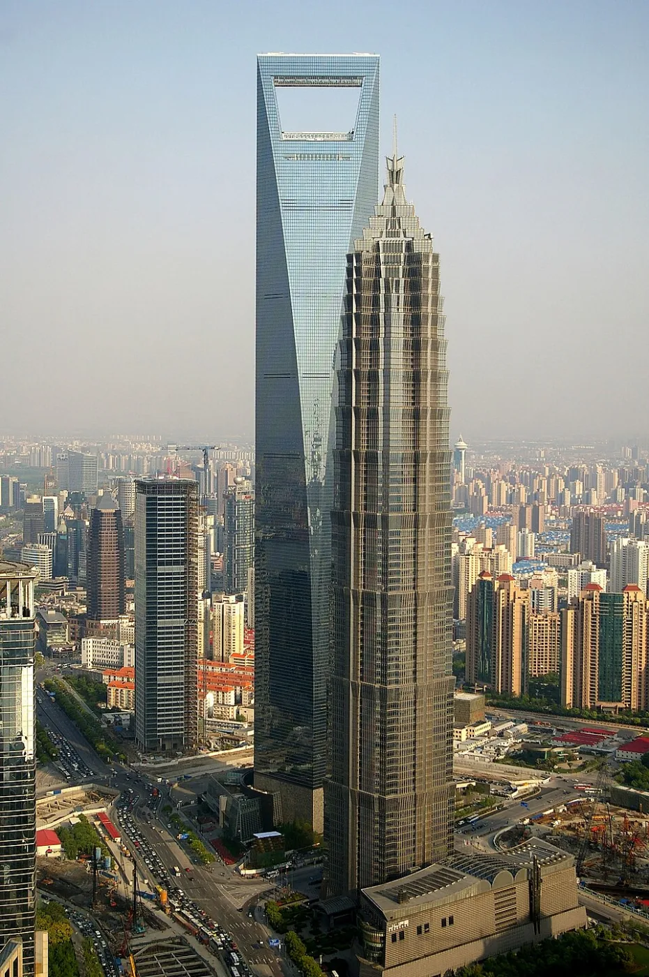 Two supertall towers rising side by side above a dense city