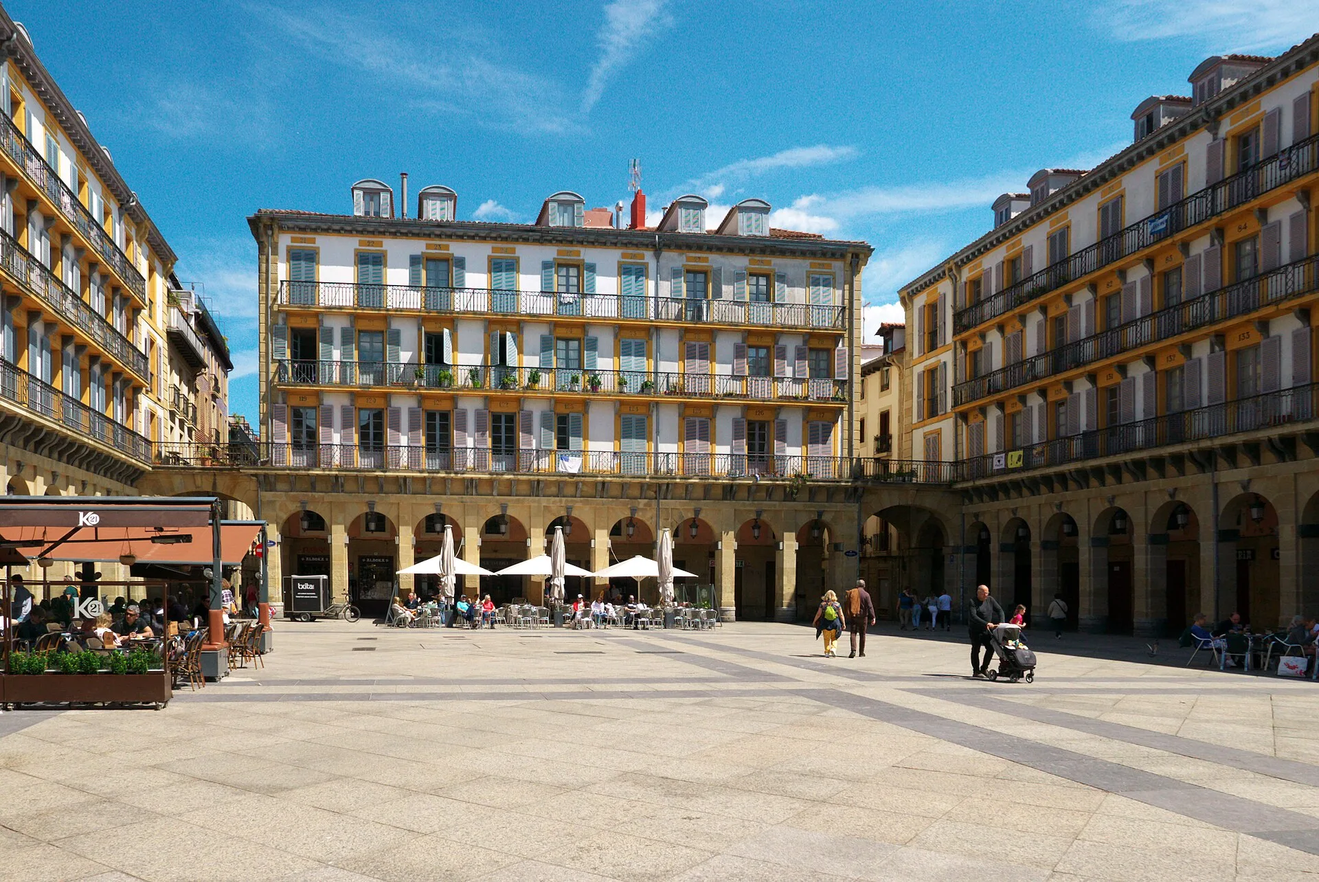 Arcaded square surrounded by apartment buildings with rows of balconies