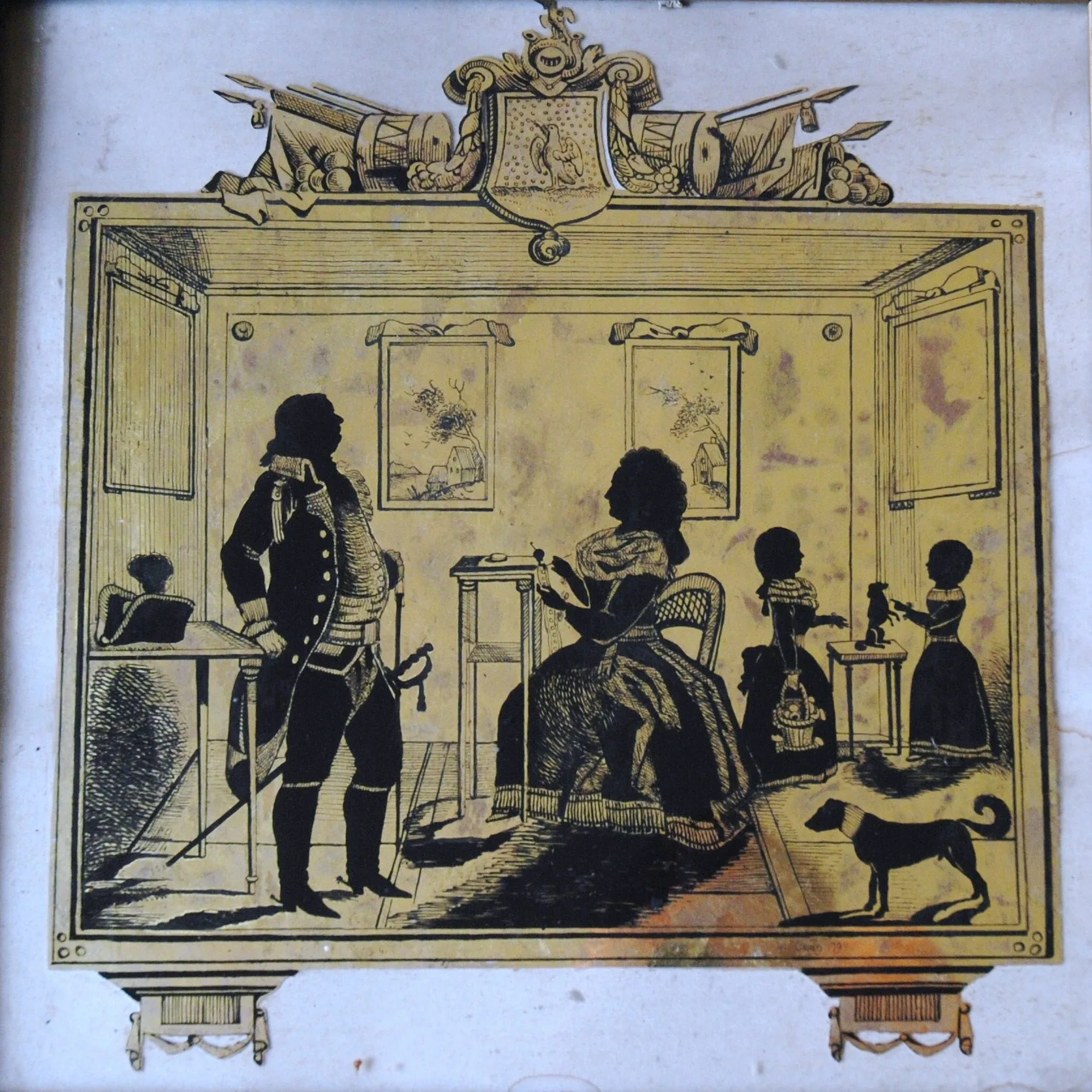 Black silhouette figures of a family in a room painted on gold glass