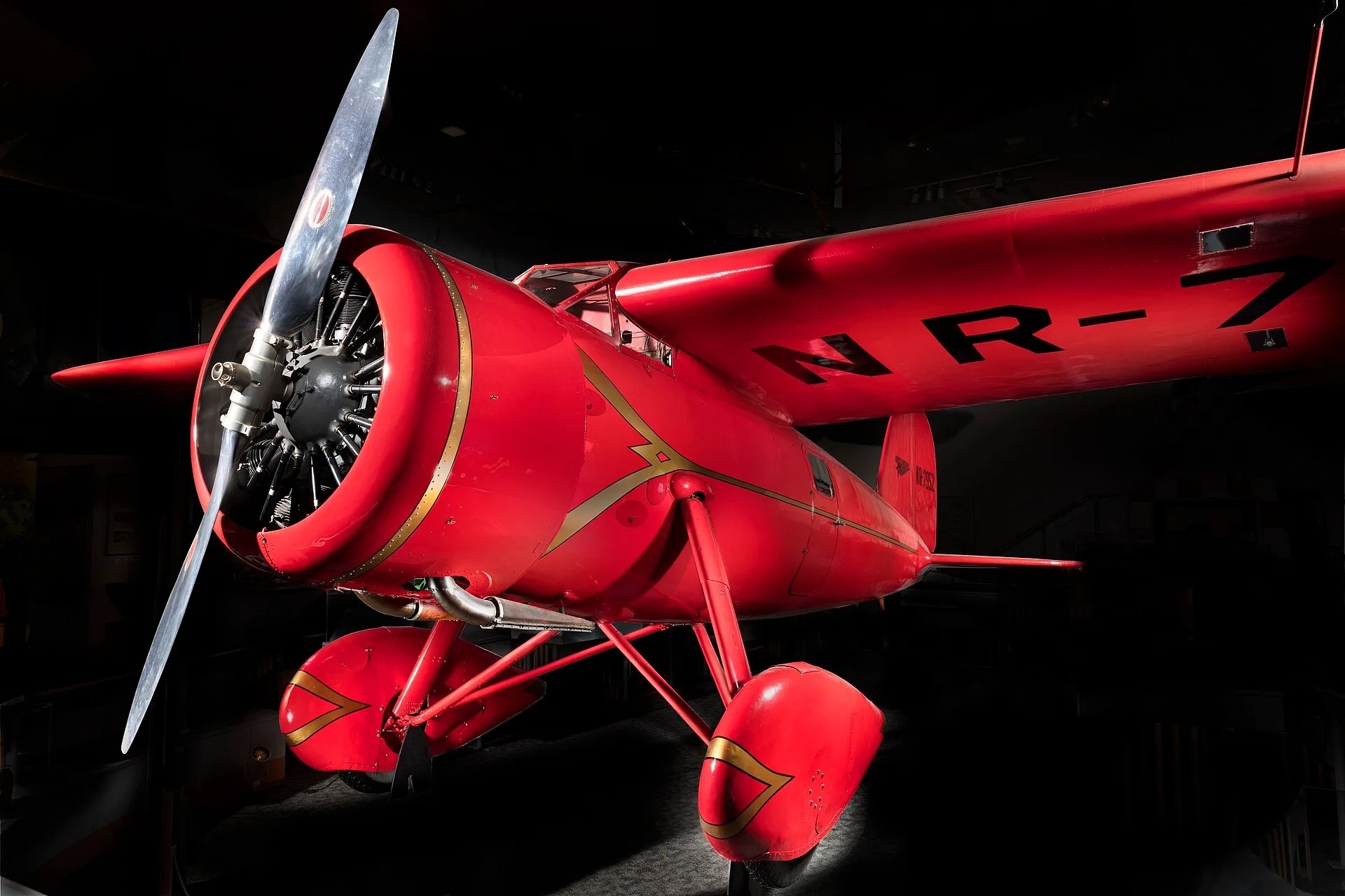 Red single-engine monoplane with streamlined engine cowling and wheel fairings