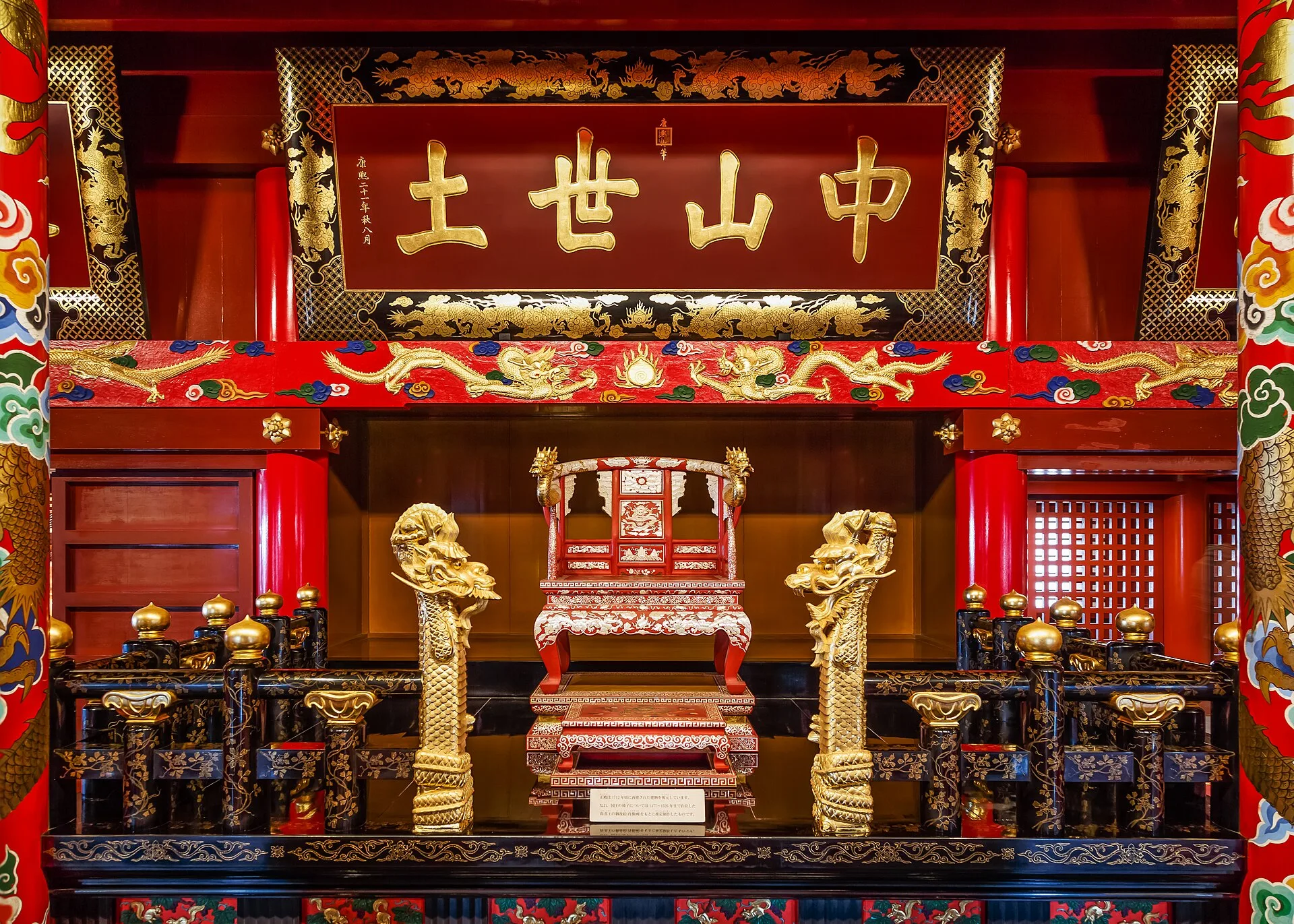 Red and gold throne beneath a gilded plaque with four Chinese characters