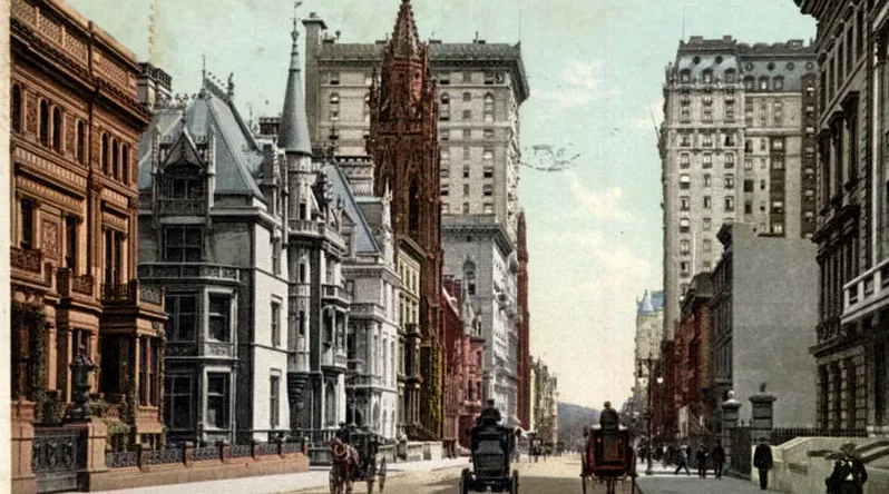 Coloured postcard view of a city avenue with mansions, a tall hotel and carriages