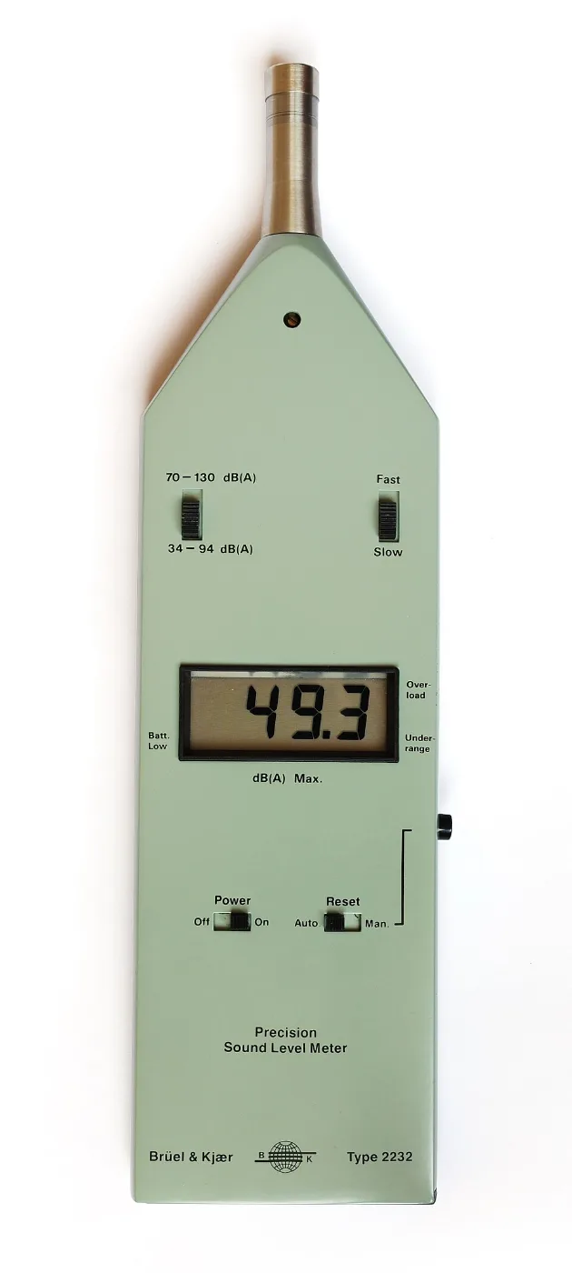 Pale green handheld sound level meter with a digital display and microphone