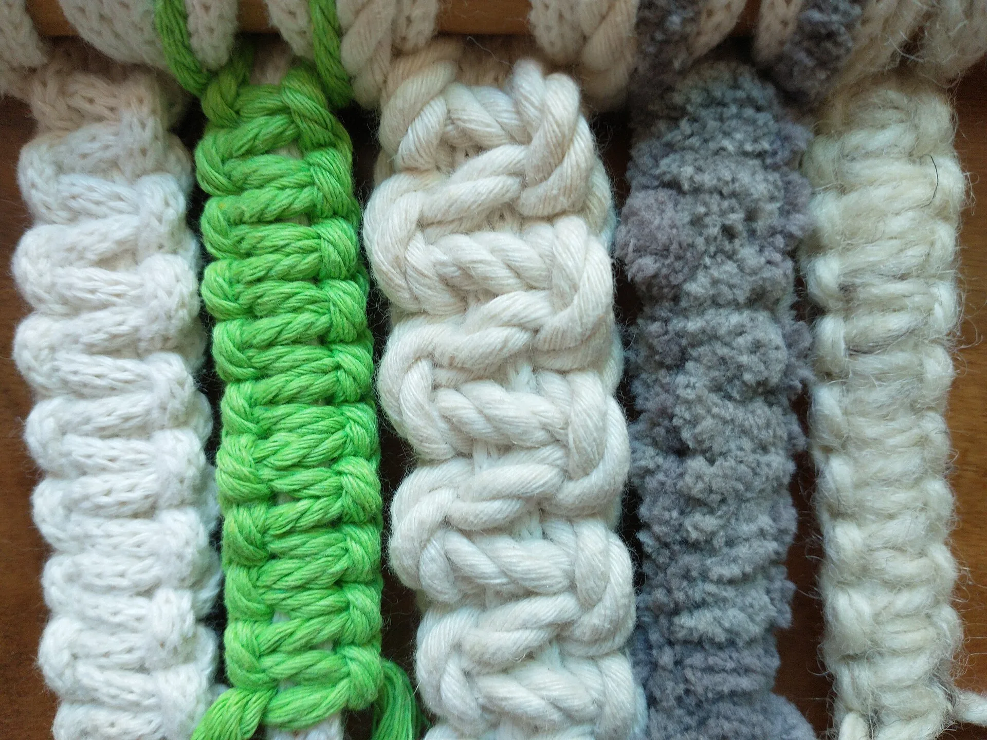 Knotted samples in white, green and grey yarns and cords side by side