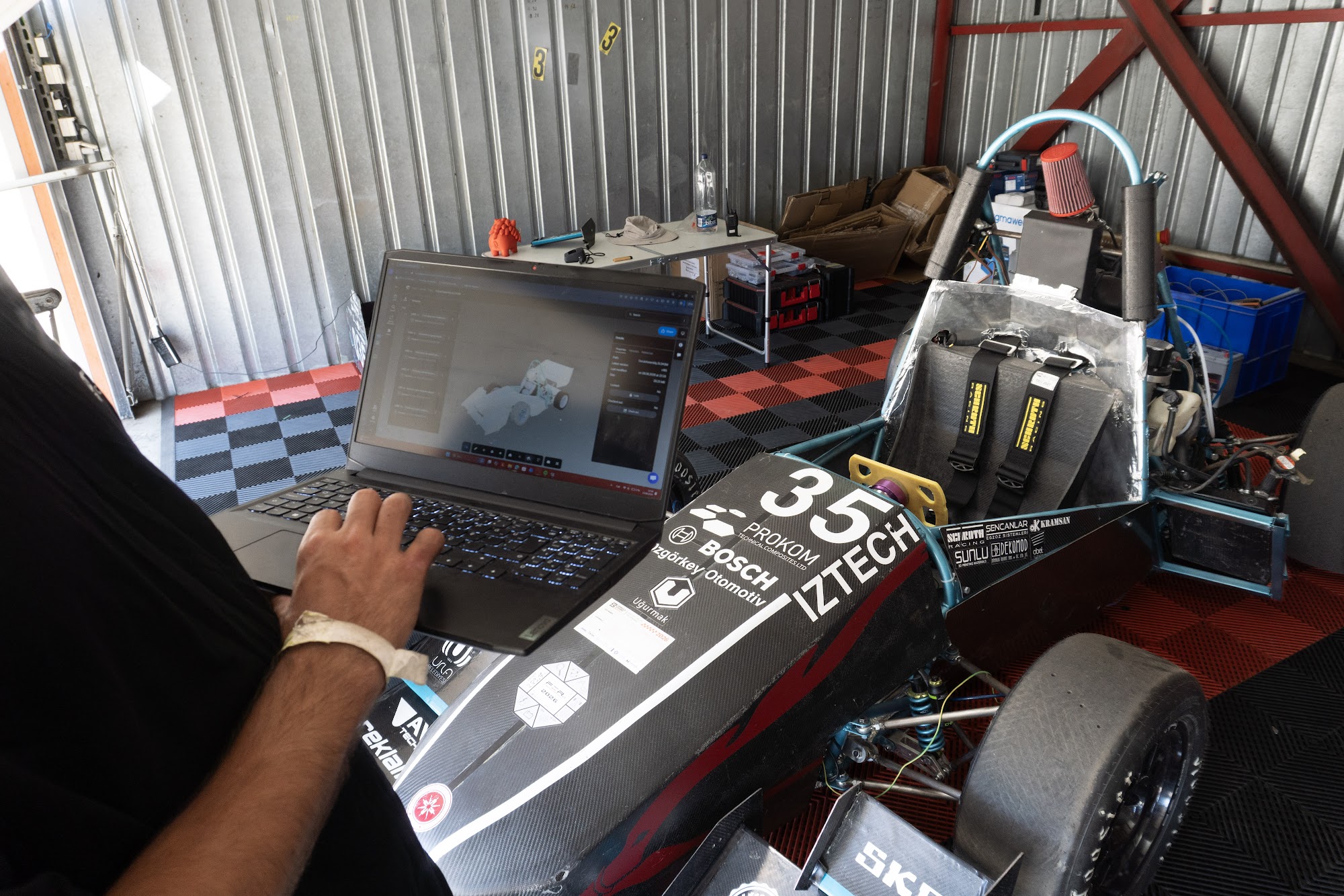 IZTECH Racing engineer reviewing the car assembly in the Sibe Web Dashboard next to the car at competition