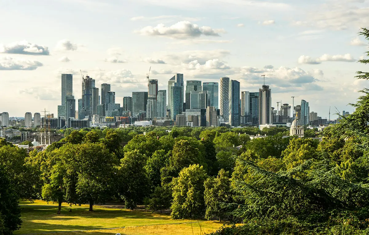 The London financial district skyline viewed from a park, representing the growth and consolidation of the UK financial services and pension sectors.