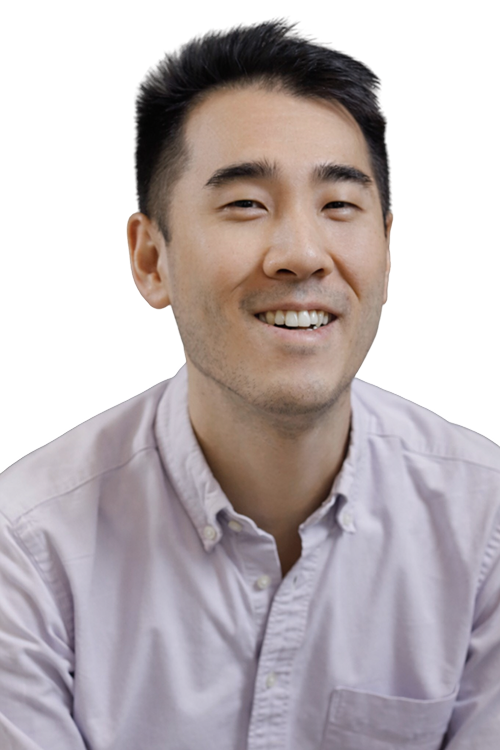 Smiling man with short black hair wearing a light purple button-up shirt.
