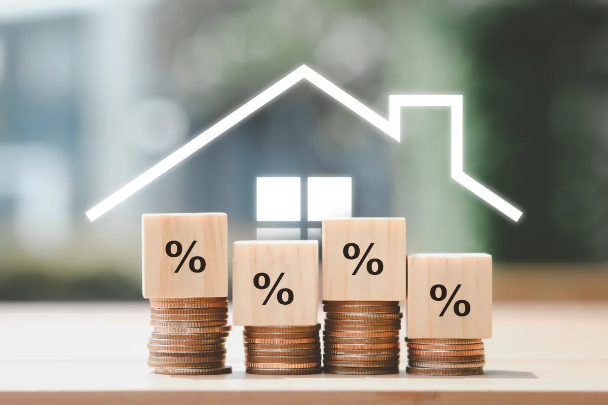 Symbole d'une maison avec des pièces de monnaie et des % au-dessus