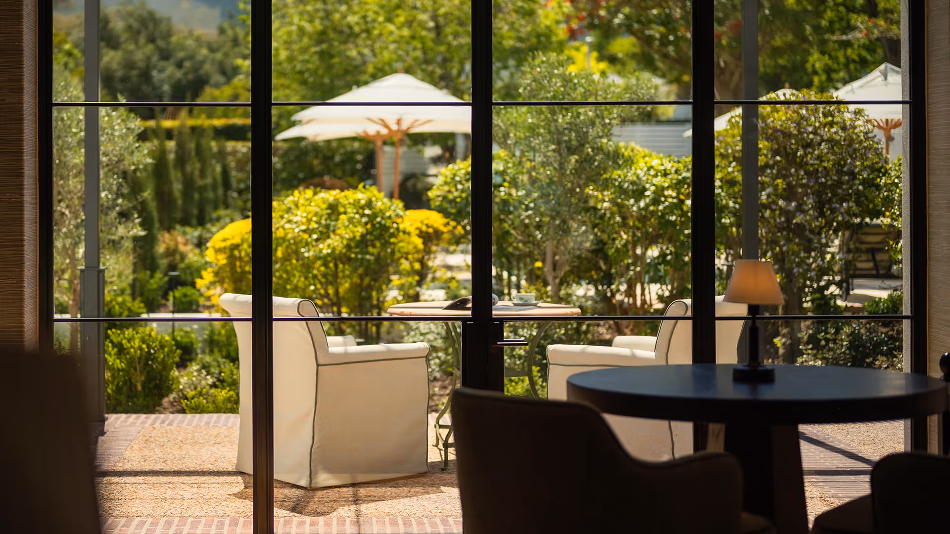 Luxury dining room interior with a view of a beautiful, lush green garden with patio furniture