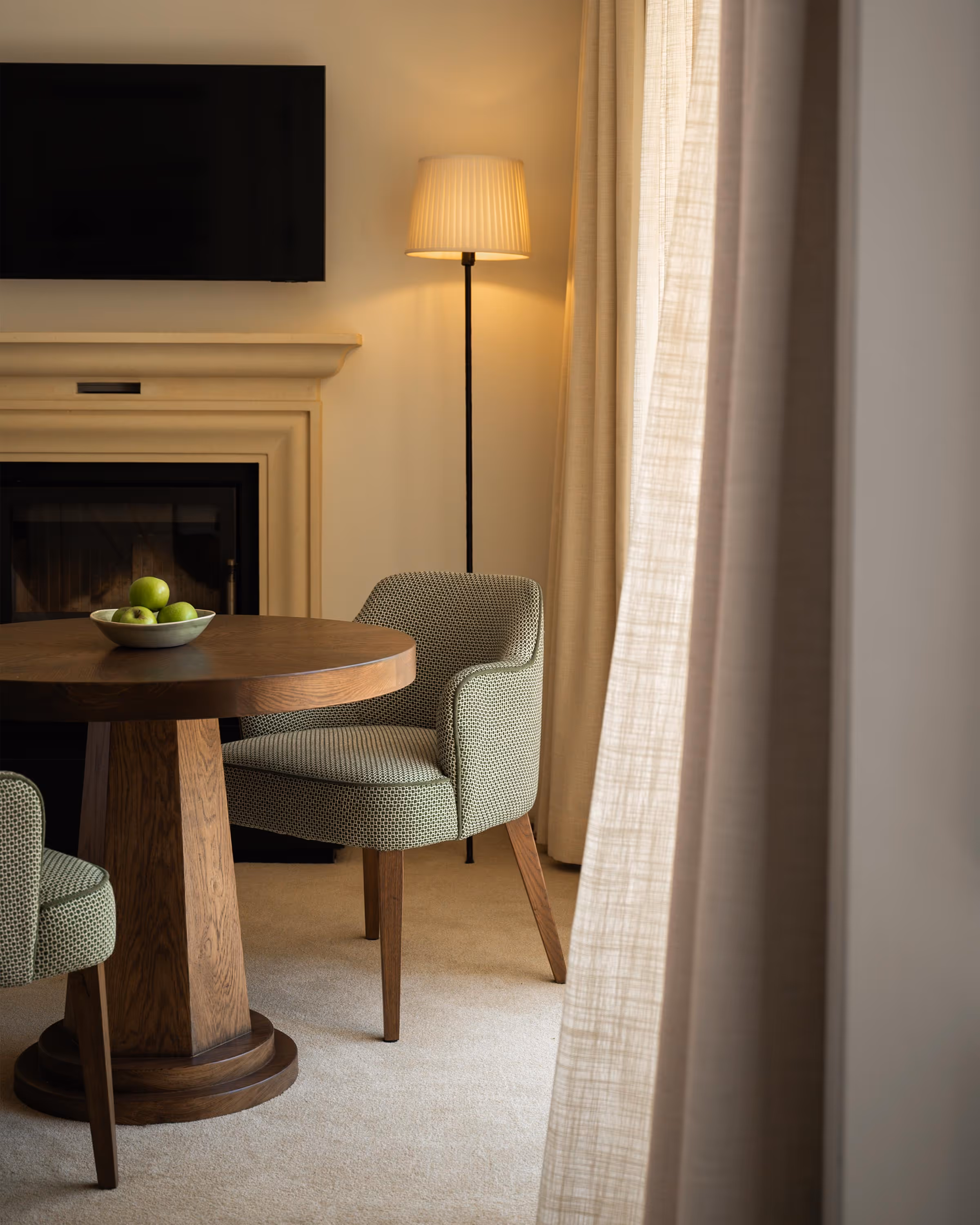 Luxury room interior with a small seating area and TV above a fireplace