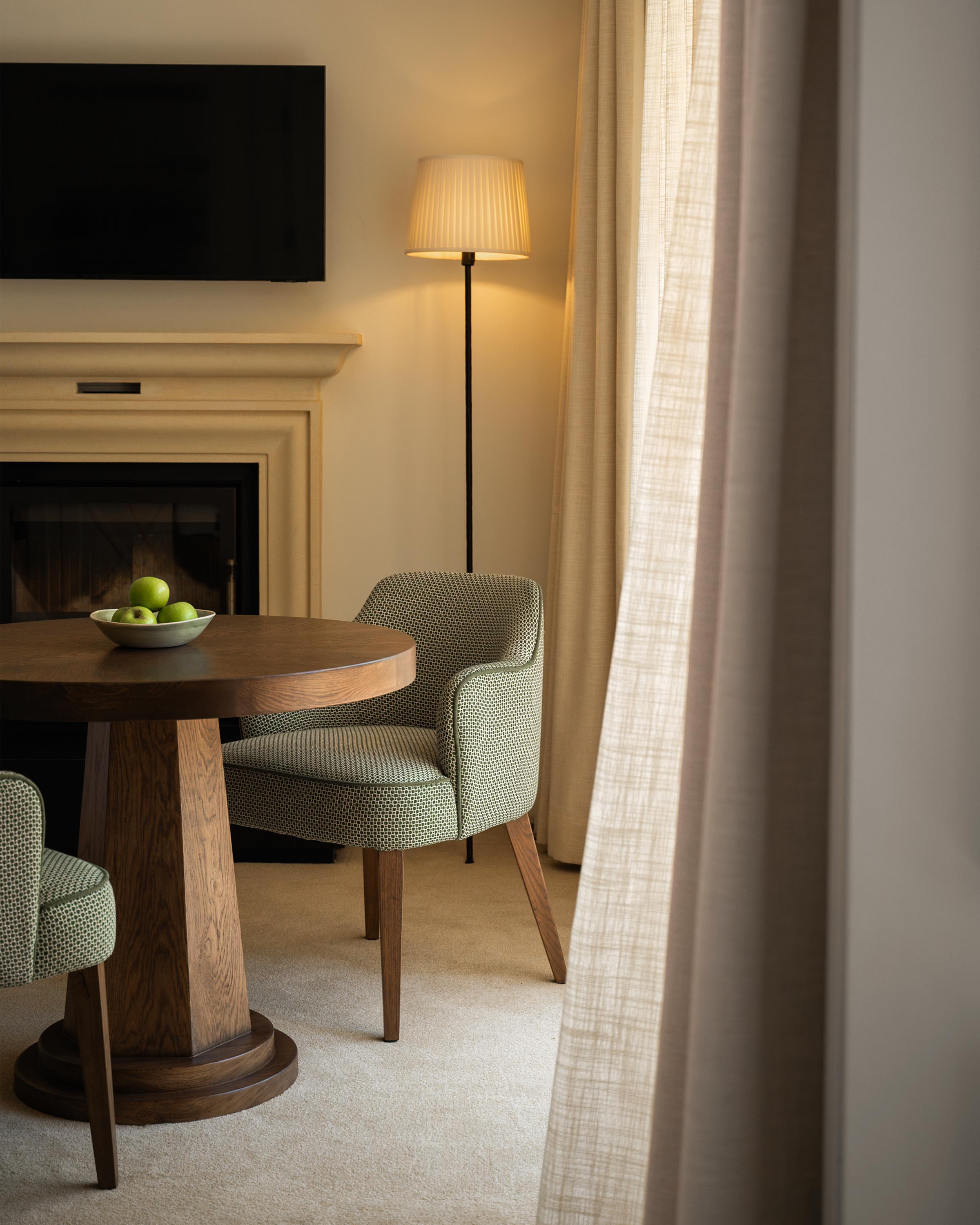 Luxury room interior with a small seating area and TV above a fireplace