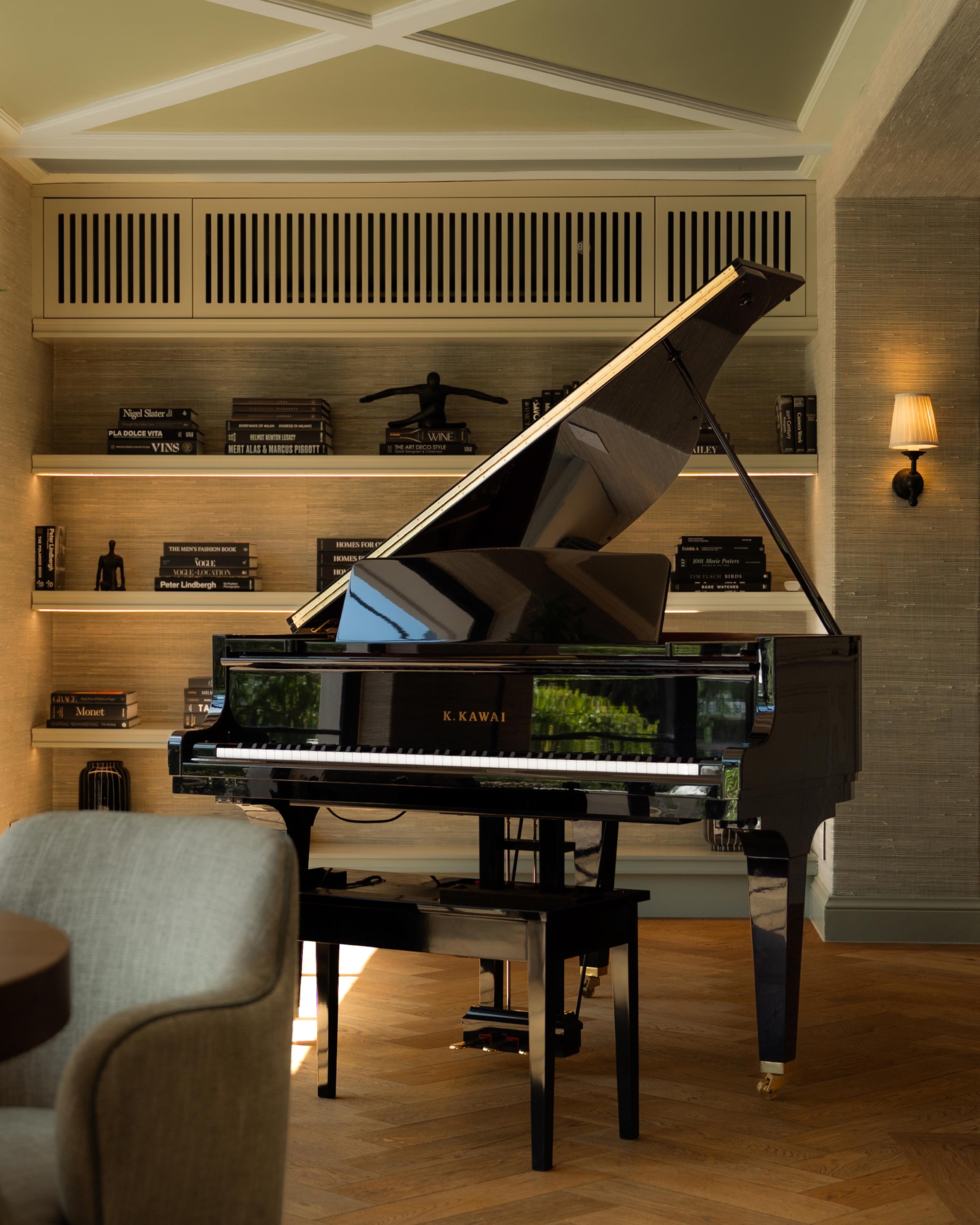 Luxury interior of a dining room with a black grand piano in the background in front of a bookcase