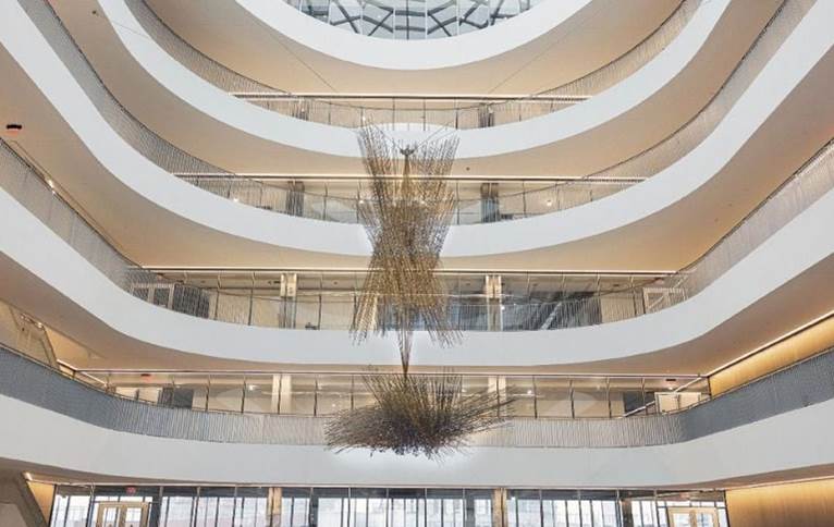 a sculpture hangs from the ceiling of a tall atrium