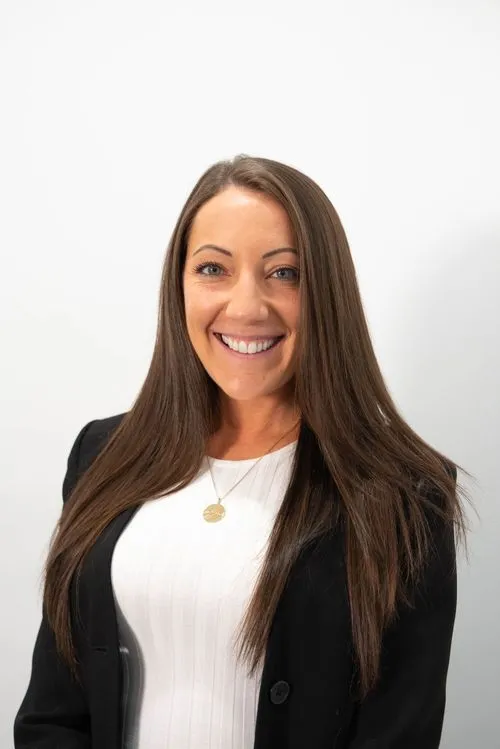A woman wearing a white shirt and black jacket.