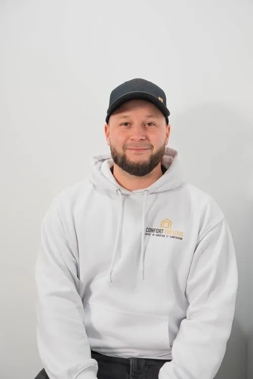 A man wearing a black hat and a white hoodie.
