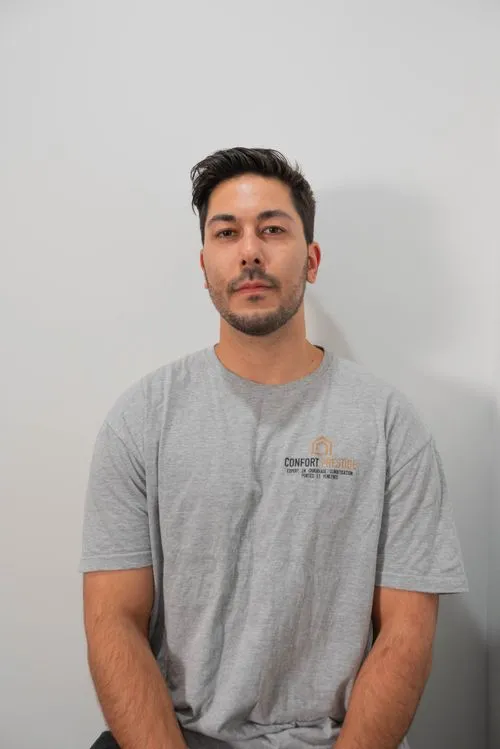 A man wearing a gray shirt with the words comfort control on it.