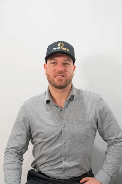 A man wearing a black hat and a grey shirt.