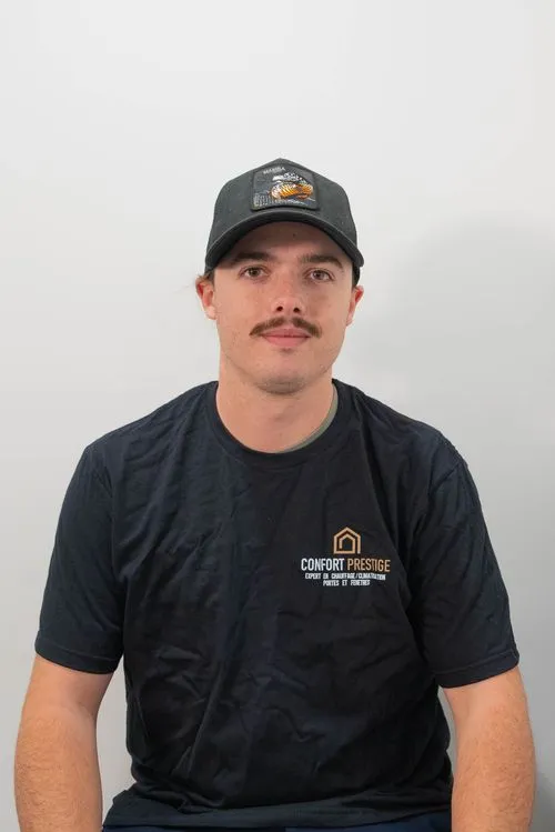 A man wearing a black hat and a blue shirt with the words Comfort Premier on it.