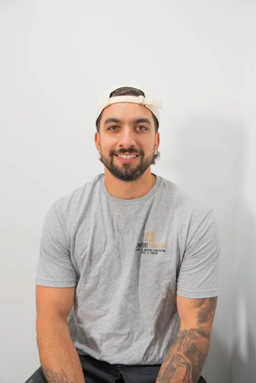 A man wearing a white hat and a grey shirt.