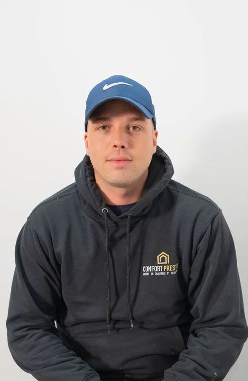 A man wearing a blue Nike hat and a grey hoodie.