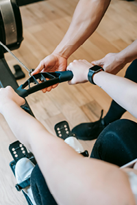 A person having their workout assisted to illustrate the coaching in fitness we off at Complexion Medspa Cobourg