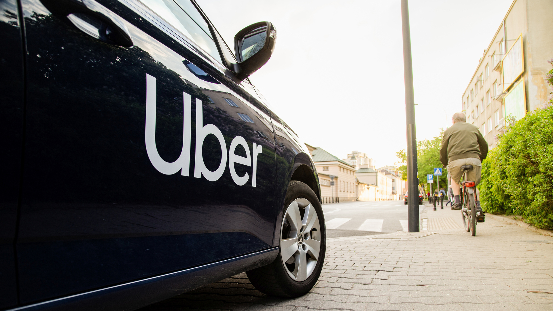 Black car with the Uber brand on the streets of a city.