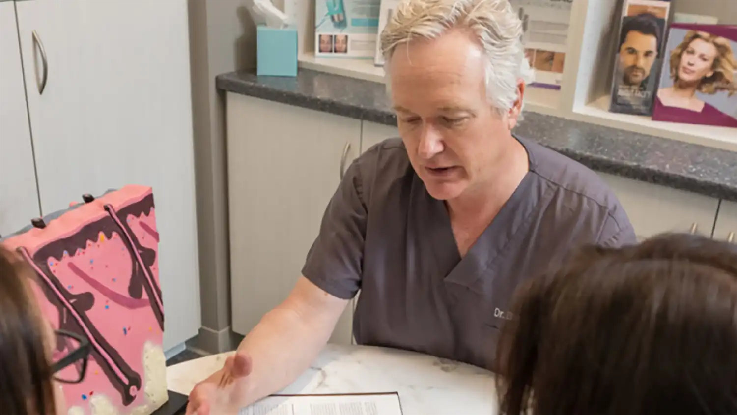 Dr. LaBine consulting with a patient in a treatment room, highlighting personalized skincare planning and attentive dermatologic care.