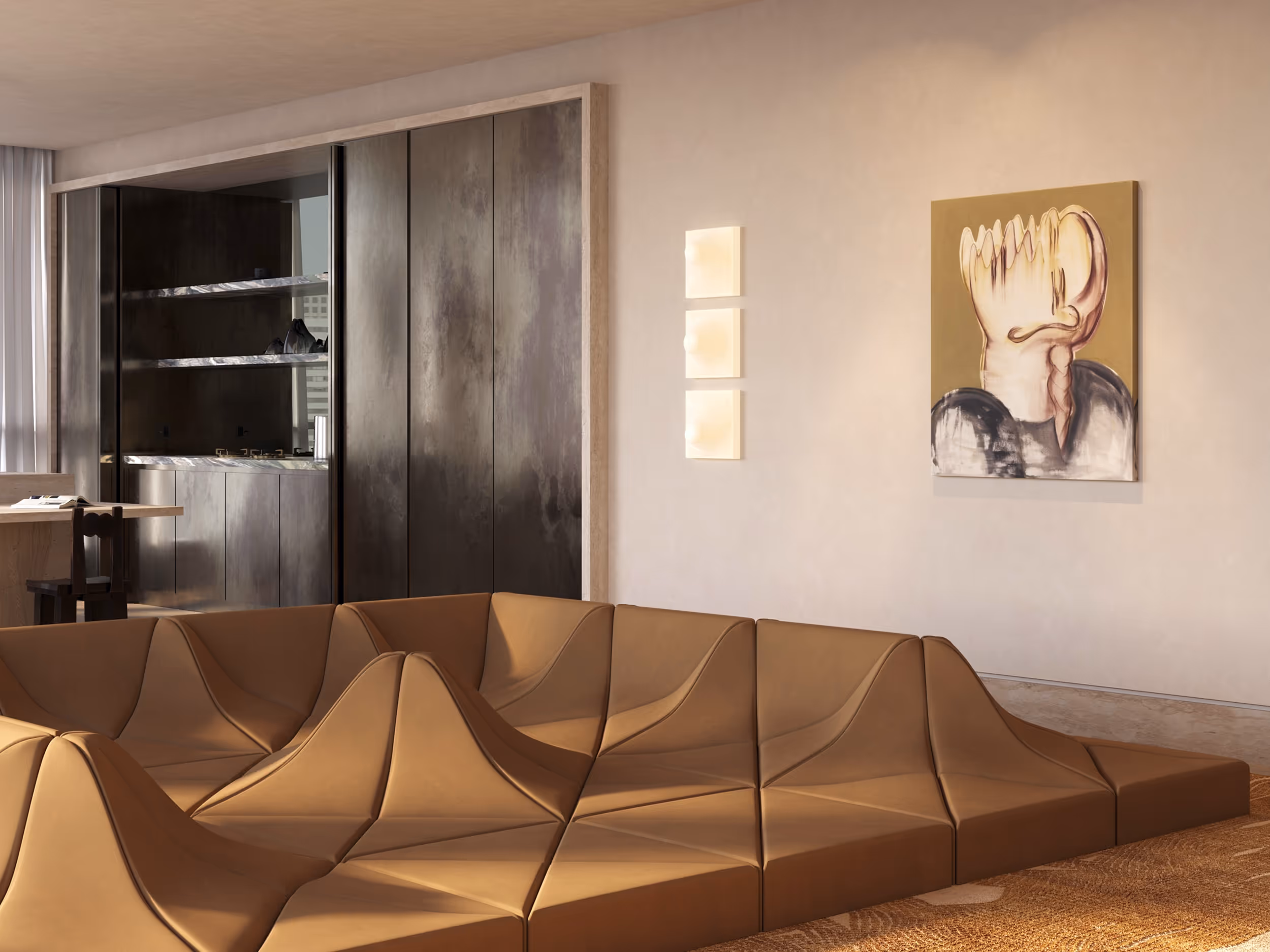 Artful living room featuring a tan Dune sofa by Pierre Paulin with geometric, wave-like forms. Abstract wall art and a trio of vintage space age wall sconces add character. Behind the seating area, dark-toned built-in kitchen and textured walls contrast with soft natural light. {horizontal}