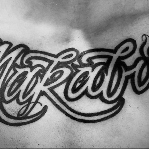 Bold cursive large script tattoo on the chest by Juse
