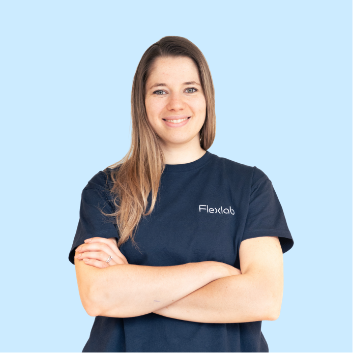 Portrait d’une flexologue de Flexlab, posant en posture confiante et professionnelle, vêtue du t-shirt bleu marine de l’équipe. Cette photo illustre l’expertise féminine et l’énergie calme qui caractérisent les séances de stretching personnalisées chez Flexlab.