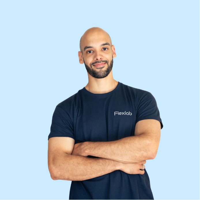 Photo d’un membre de l’équipe Flexlab posant bras croisés, avec un regard déterminé et détendu. Cette posture exprime force tranquille, expertise et fiabilité dans l’accompagnement du bien-être musculaire.