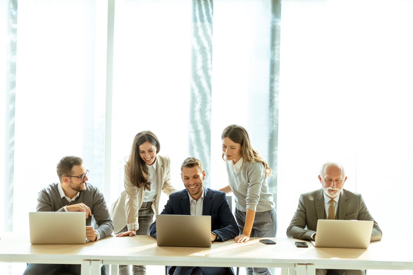 Grupa osób w jasnym biurze na spotkaniu biznesowym.